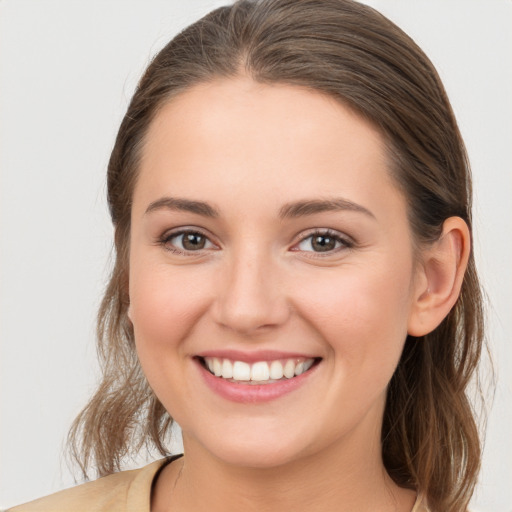 Joyful white young-adult female with medium  brown hair and grey eyes