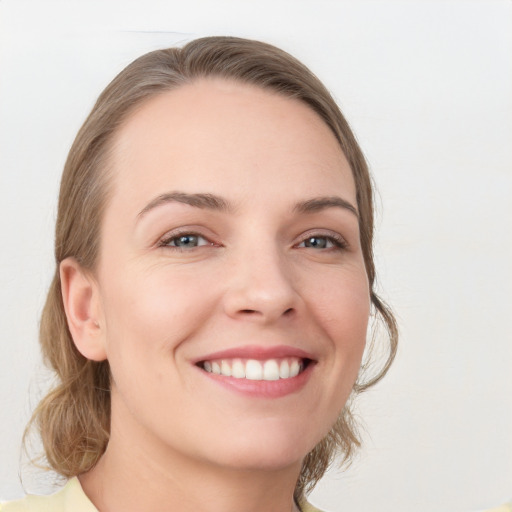 Joyful white young-adult female with medium  brown hair and grey eyes