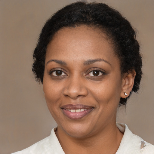 Joyful black young-adult female with short  brown hair and brown eyes