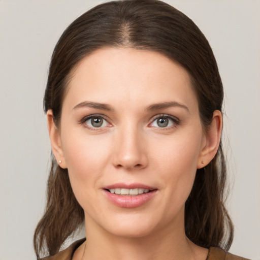 Joyful white young-adult female with medium  brown hair and grey eyes