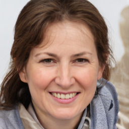 Joyful white adult female with medium  brown hair and brown eyes