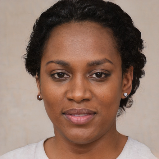 Joyful black young-adult female with short  black hair and brown eyes