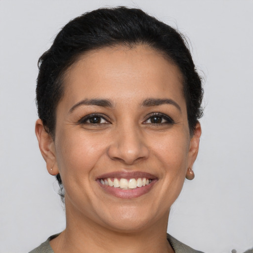 Joyful latino young-adult female with short  brown hair and brown eyes