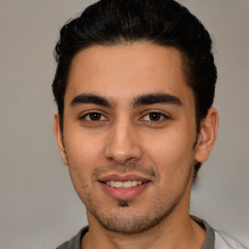 Joyful white young-adult male with short  black hair and brown eyes