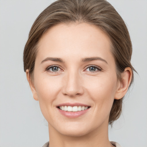 Joyful white young-adult female with medium  brown hair and grey eyes