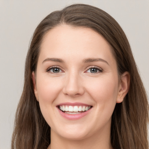 Joyful white young-adult female with long  brown hair and grey eyes