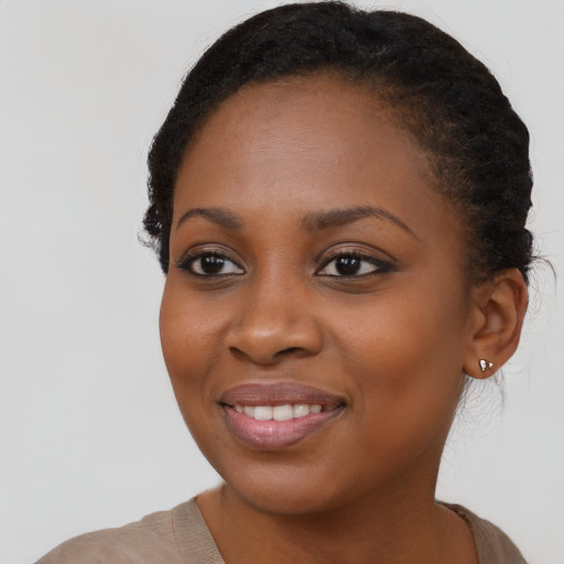 Joyful black young-adult female with long  brown hair and brown eyes