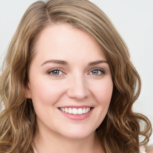 Joyful white young-adult female with long  brown hair and green eyes