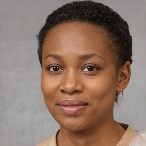 Joyful black young-adult female with short  brown hair and brown eyes