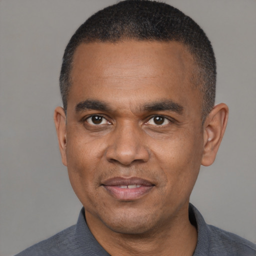 Joyful black adult male with short  black hair and brown eyes