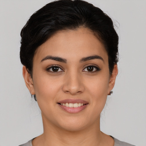 Joyful latino young-adult female with short  brown hair and brown eyes
