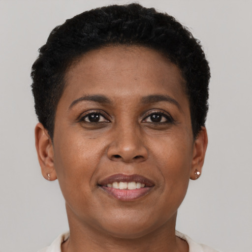 Joyful black adult female with short  brown hair and brown eyes