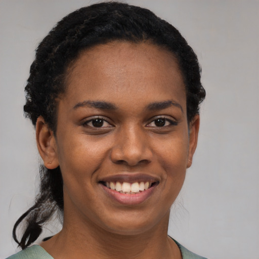 Joyful black young-adult female with short  black hair and brown eyes
