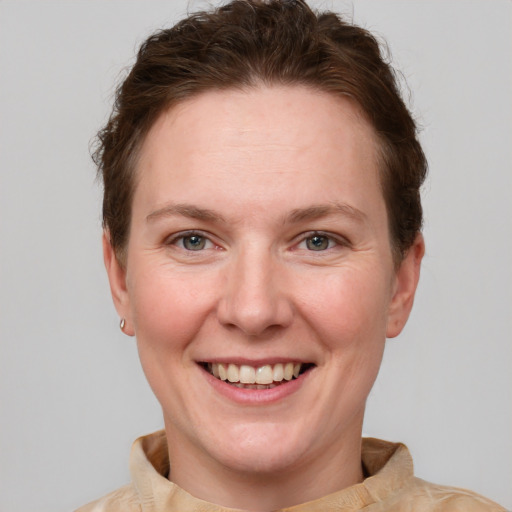 Joyful white adult female with short  brown hair and grey eyes