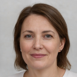 Joyful white adult female with medium  brown hair and grey eyes