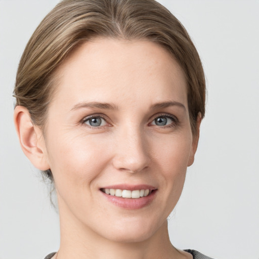 Joyful white young-adult female with medium  brown hair and grey eyes