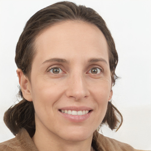 Joyful white young-adult female with medium  brown hair and grey eyes