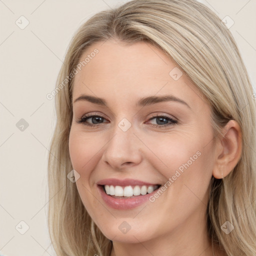 Joyful white young-adult female with long  brown hair and blue eyes