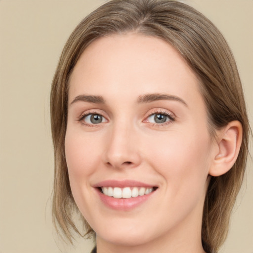 Joyful white young-adult female with medium  brown hair and green eyes