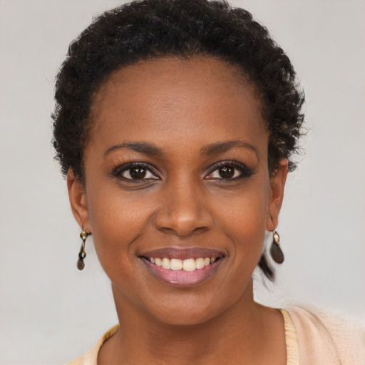 Joyful black young-adult female with short  brown hair and brown eyes