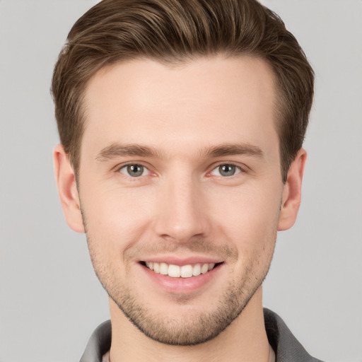 Joyful white young-adult male with short  brown hair and grey eyes