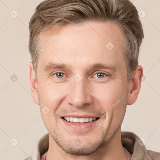 Joyful white adult male with short  brown hair and grey eyes