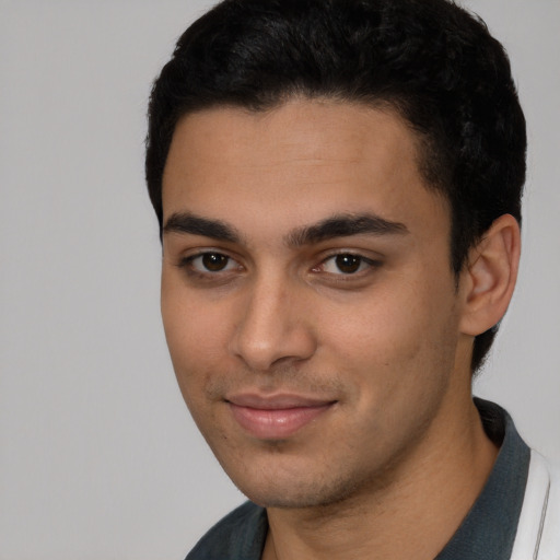 Joyful latino young-adult male with short  black hair and brown eyes