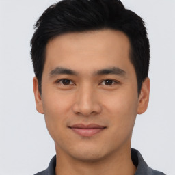 Joyful asian young-adult male with short  black hair and brown eyes