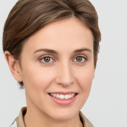 Joyful white young-adult female with short  brown hair and grey eyes