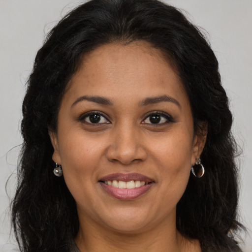 Joyful latino adult female with long  brown hair and brown eyes