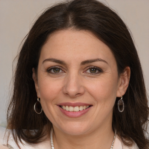 Joyful white adult female with medium  brown hair and brown eyes