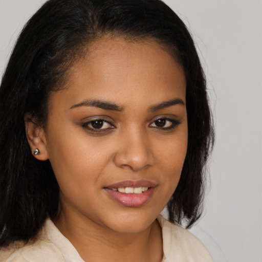 Joyful black young-adult female with long  brown hair and brown eyes