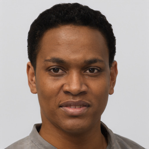 Joyful black young-adult male with short  black hair and brown eyes
