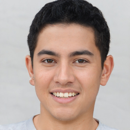 Joyful latino young-adult male with short  brown hair and brown eyes