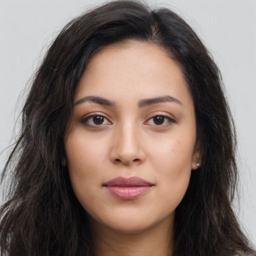 Joyful latino young-adult female with long  brown hair and brown eyes