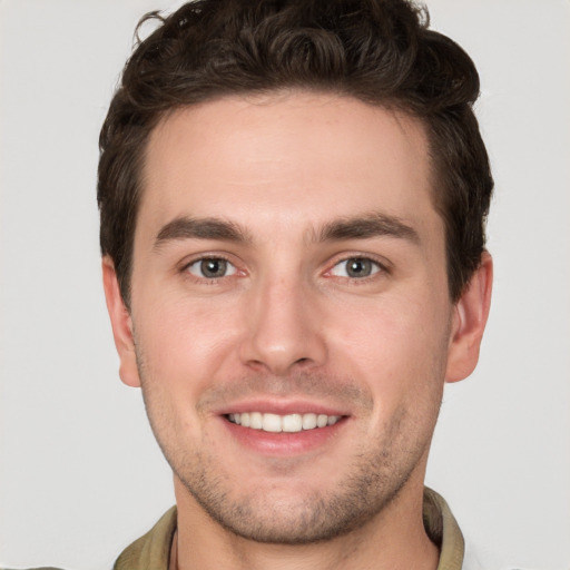 Joyful white young-adult male with short  brown hair and grey eyes