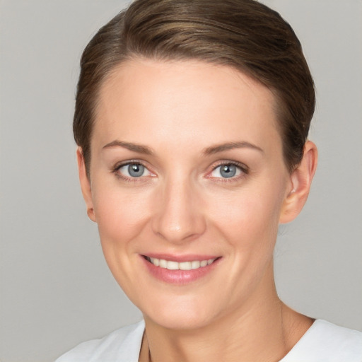 Joyful white young-adult female with short  brown hair and grey eyes