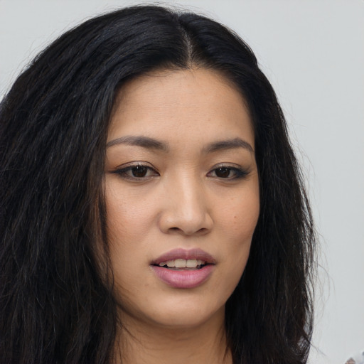 Joyful asian young-adult female with long  brown hair and brown eyes