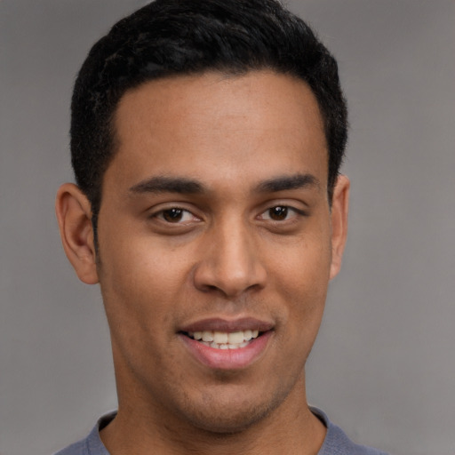 Joyful latino young-adult male with short  brown hair and brown eyes