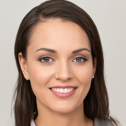 Joyful white young-adult female with long  brown hair and grey eyes