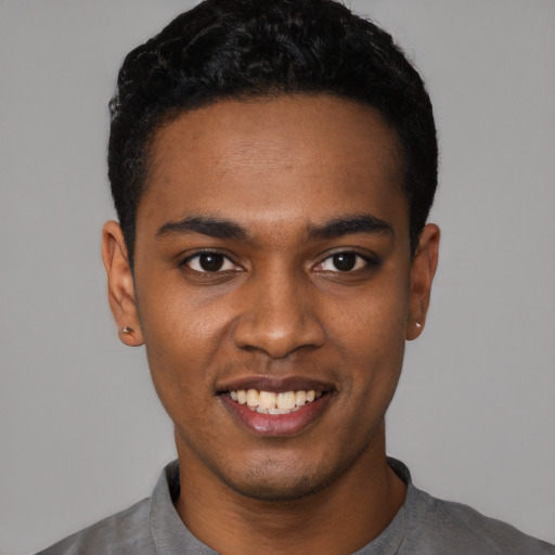 Joyful black young-adult male with short  black hair and brown eyes