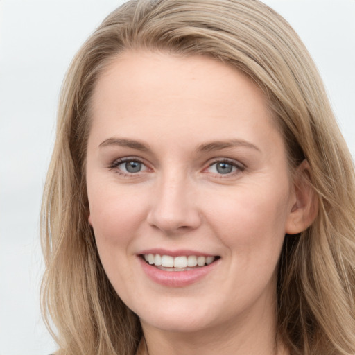 Joyful white young-adult female with long  brown hair and blue eyes