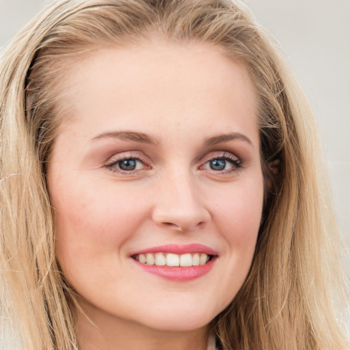 Joyful white young-adult female with long  brown hair and blue eyes