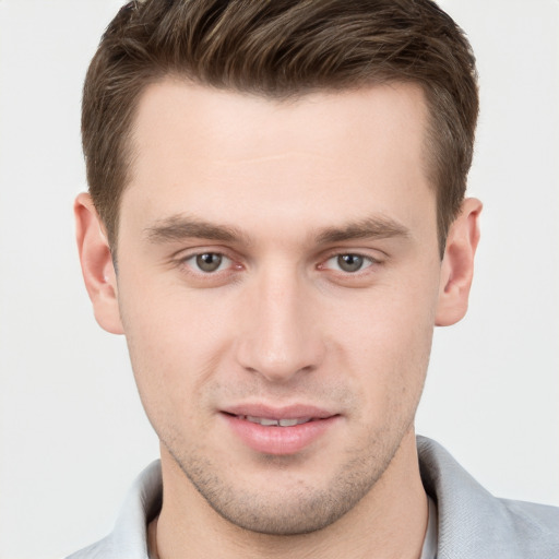 Joyful white young-adult male with short  brown hair and grey eyes