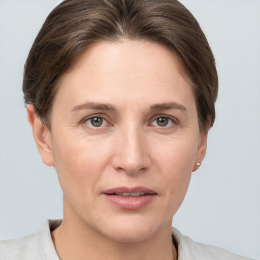 Joyful white young-adult female with short  brown hair and grey eyes