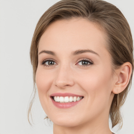 Joyful white young-adult female with long  brown hair and green eyes