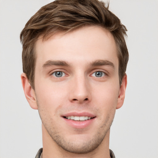 Joyful white young-adult male with short  brown hair and grey eyes