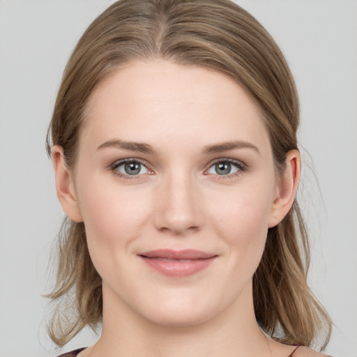 Joyful white young-adult female with medium  brown hair and grey eyes