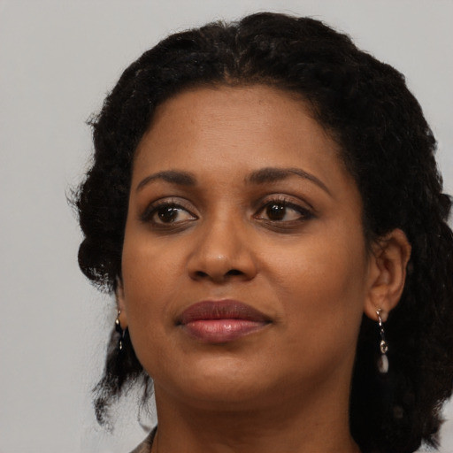 Joyful black young-adult female with medium  black hair and brown eyes