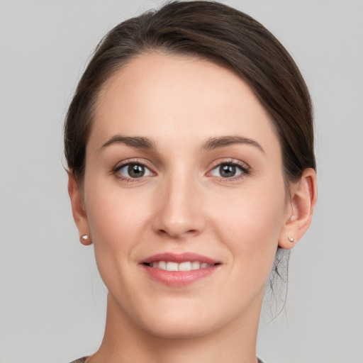 Joyful white young-adult female with short  brown hair and grey eyes